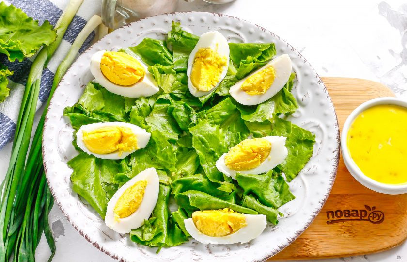 1. Этап. Салат с мидиями и авокадо: Промойте листья салата, обсушите их бумажным полотенцем и нарвите руками на тарелку. Отварные яйца очистите от скорлупы, промойте в воде и нарежьте на четвертинки. Выложите на зелень.