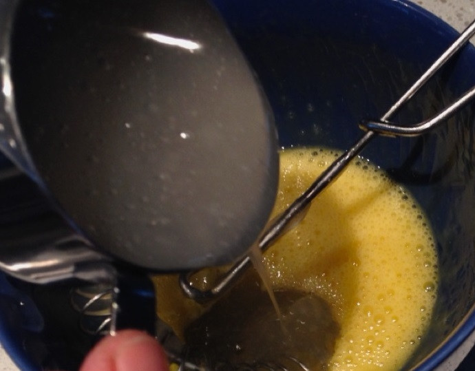 1. Этап. Капкейки с лимонным курдом и меренгой: 3. В миске размешайте куриный желток, влейте в него небольшое количество горячего сиропа. Хорошенько взбивайте, чтобы желток не свернулся.