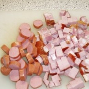 1. Этап. Солянка в мультиварке: Пока овощи тушатся, нарежьте копчености небольшими кусочками.