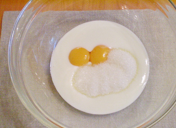 1. Этап. Оладьи на кефире пышные: В глубокую посуду добавляем: кефир комнатной температуры, желтки (предварительно отделенные от белков) и сахар. Всё тщательно взбиваем венчиком.