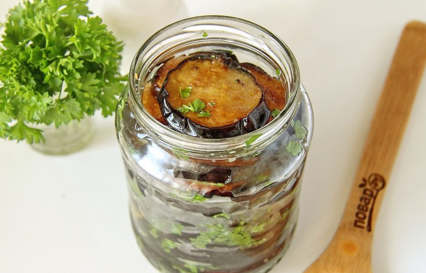 1. Этап. Баклажаны на зиму без уксуса: В стерилизованные банки выложите обжаренные баклажаны, пересыпая их солью и зеленью.