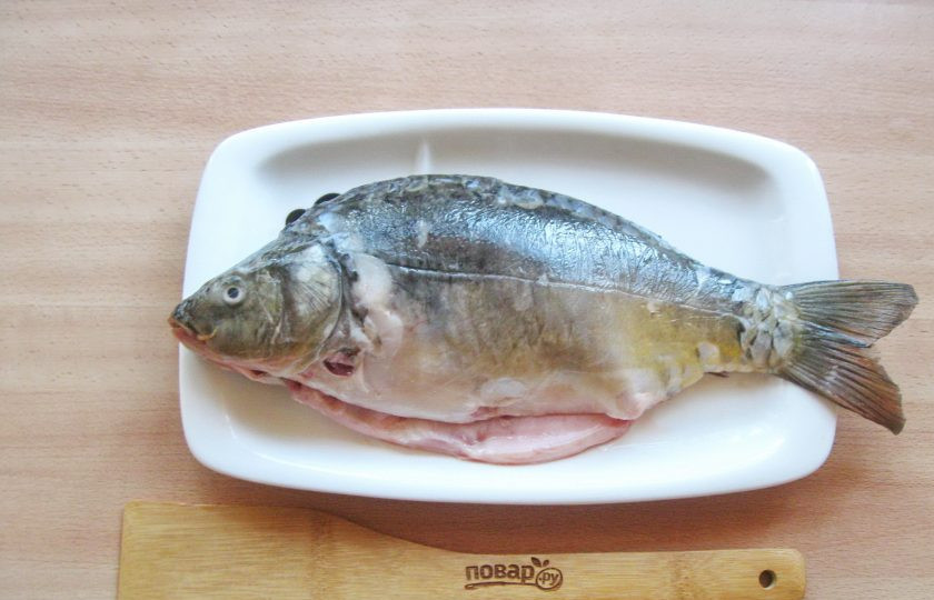 1. Этап. Карп в духовке на луковой подушке: Карпа очистите, выпотрошите, удалите спинные плавники и жабры. Тщательно помойте внутри и снаружи.