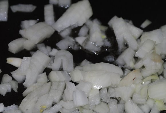 1. Этап. Свиная рулька по-немецки: Вторую луковицу почистите, измельчите. Обжарьте в масле в течение 4 минут.