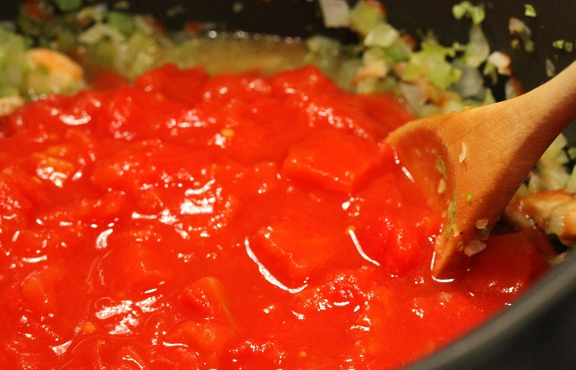 1. Этап. Томатно-мясной соус: Затем к овощам добавляем помидоры в собственном соку. До того как добавить их на сковородку, вылейте их в тарелку и хорошенько разомните руками.