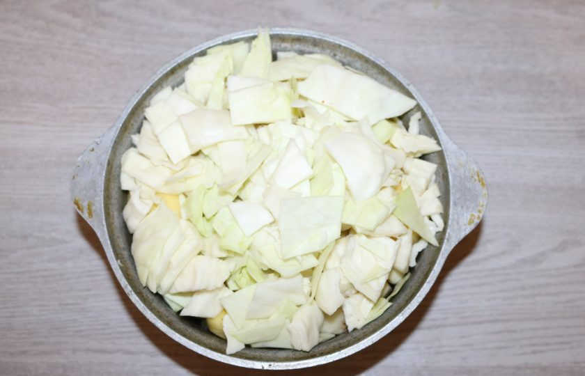 1. Этап. Басма: У капусты снимите несколько верхних листьев, оставьте их для верха блюда. Выложите чеснок. Капусту крупно нарежьте, выложите сверху.