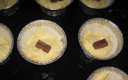 1. Этап. Творожные кексы с шоколадом: 3. В подготовленные формы, положите по одной столовой ложке теста сверху, слегка надавливая, разложите по кусочку шоколада.