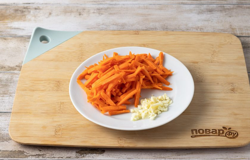 1. Этап. Замороженная стручковая фасоль на сковороде: Морковь очистите и порежьте брусочками. Чеснок мелко порубите.