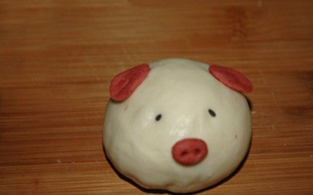 1. Этап. Паровые булочки по-вьетнамски: Украсьте булочку ушками, пятачком, сделанными из розового теста. Глазки сделайте из черного кунжута.