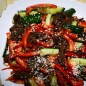 Тёплый мясной салат в азиатском стиле Огурцы моем, нарезаем небольшими брусочками, немного подсаливаем и оставляем на 15-20 минут, чтобы они выпустили как можно больше сока Перед тем как нарезать говядину, мы её немного подмораживаем, нам нужна очень тонкая! нарезка Тонкими полукольцами режем лук и болгарский перец Огурцы отжимаем и перекладываем на блюдо на котором будем подавать салат На хорошо разогретой сухой сковороде без добавления масла в течение 1 минуты обжариваем мясо для появления аппетитной корочки. С помощью щипцов или палочек постоянно мешаем и переворачиваем. К мясу добавляем лук, соевый соус, убавляем огонь и тушим под крышкой минут 20, периодически помешивая. Готовое мясо выкладываем на огурцы, сверху болгарский перец, выдавленный через пресс чеснок, сахар, специи, уксус, растительное масло и аккуратно перемешиваем. Посыпаем кунжутом, по желанию предварительно поджаренным. Приятного аппетита!