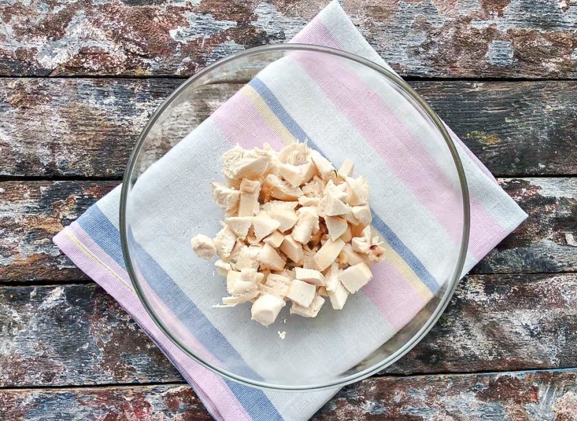 1. Этап. Салат с курицей и арахисом: Курицу нарежьте небольшими кусочками и выложите в глубокую тарелку.