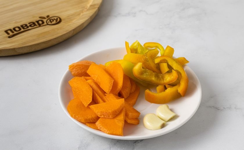 1. Этап. Маринованный топинамбур: Морковь нарежьте ломтиками, сладкий перец полукольцами, чеснок очистите и разрежьте пополам.