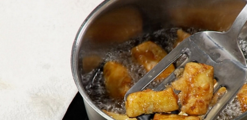 1. Этап. Баклажаны в кисло-сладком соусе по-китайски: 3. Отделяем желток от белка, в миске смешиваем белок, крахмал и немного воды, перемешиваем. Баклажаны немного отжимаем, перекладываем в тесто, перемешиваем. На огонь ставим сотейник, наливаем подсолнечное масло и опускаем баклажаны во фритюр, обжариваем и выкладываем на бумажную салфетку.