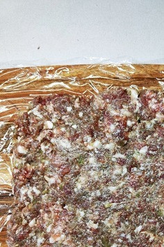 1. Этап. Мясной рулет с грибами: На пищевую пленку выложить фарш, разровнять в прямоугольник.