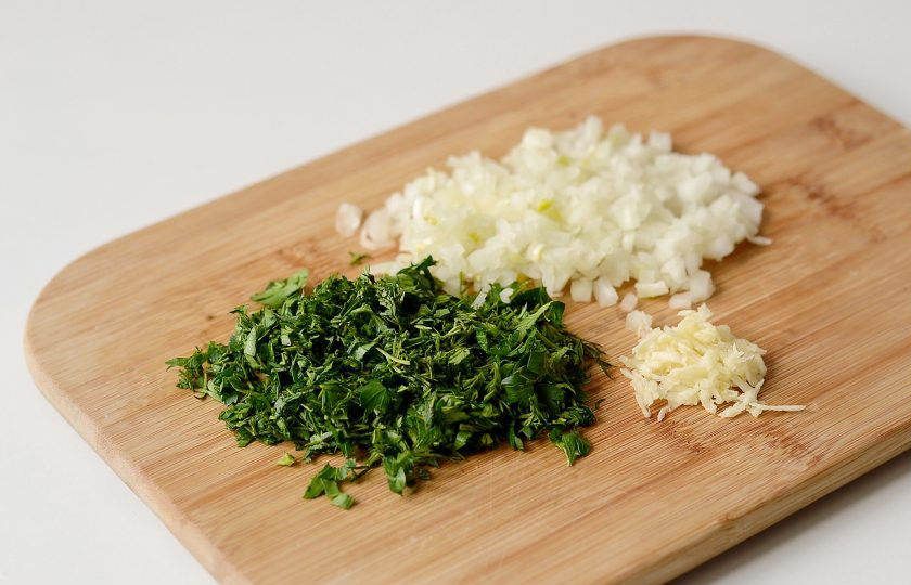 1. Этап. Баклажанная икра по-одесски: Репчатый лук и петрушку мелко порубите, чеснок пропустите через пресс.