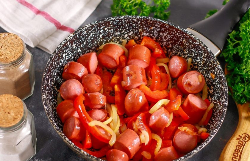 1. Этап. Сосиски по-корейски: Когда сосиски подрумянятся, а овощные нарезки еще не потеряют свою форму, нужно добавлять специи.