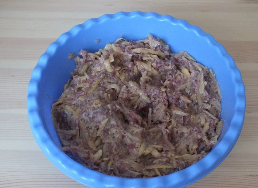 1. Этап. Бурма с мясом в духовке: В чашу с мясом и луком добавьте тертый картофель. Добавьте соль, перец, зиру и перемешайте.