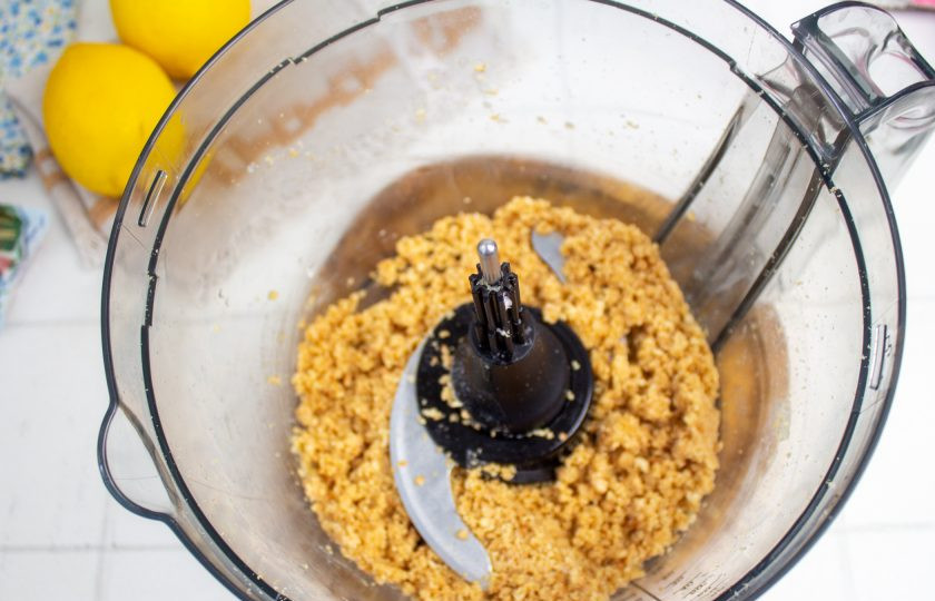 1. Этап. Лимонный чизкейк без выпечки: Добавьте к печенью растопленное сливочное масло и перемешайте все в блендере. Должна получиться консистенция как мокрый песок.