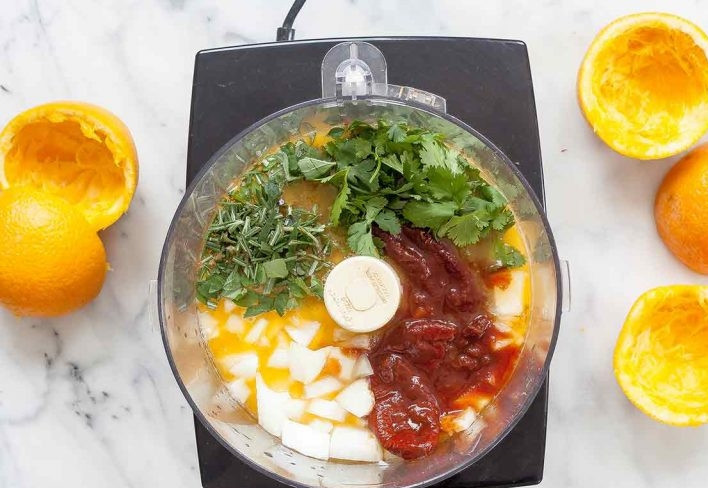 1. Этап. Куриное мясо в апельсиновом маринаде: 1. В чашу комбайна выложите апельсиновый сок, измельченный лук, перец чили, чеснок, кинзу, розмарин, тимьян, майоран и соль.