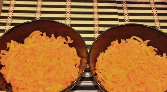 1. Этап. Салат из минтая: Сверху кладем натертую на крупной терке морковь.