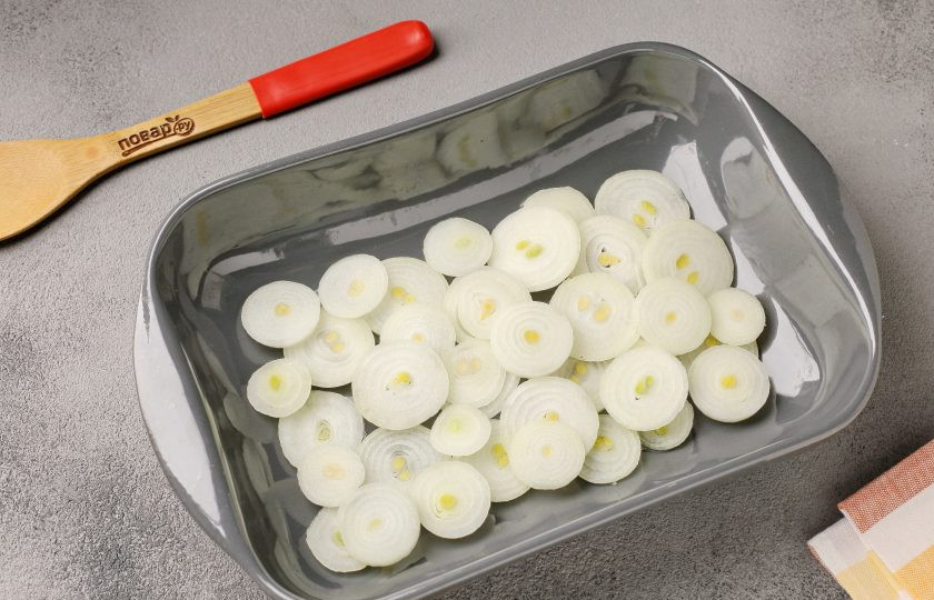 1. Этап. Кролик в соевом соусе с мёдом: Жаропрочную форму смажьте маслом. Нарежьте лук колечками и выложите на дно формы.