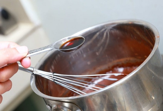 1. Этап. Вкусный торт из печенья: 7. Поставьте сотейник на огонь, проварите до однородности. Снимите с огня, выложите в сотейник масло и добавьте ванильный экстракт. Перемешайте все как следует.