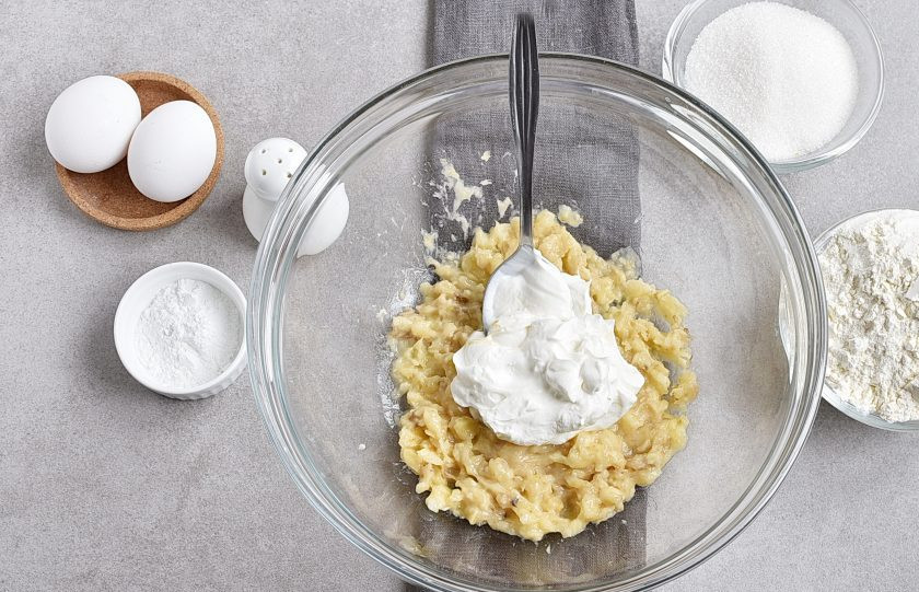 1. Этап. Банановый пирог в мультиварке: Оставшиеся бананы разомните толкушкой и смешайте со сметаной, чтобы не потемнели.