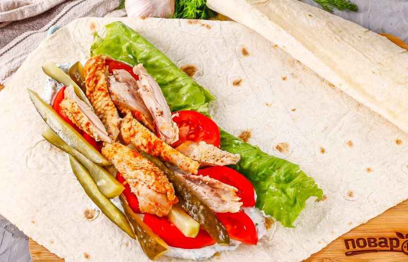 1. Этап. Азербайджанская шаурма: Промойте листья салата и стряхните с них лишнюю влагу. Выложите вместе с нарезкой куриного мяса на лаваш.