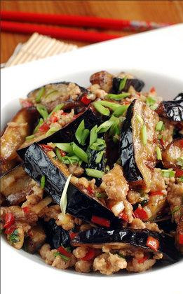 1. Этап. Баклажаны по-пекински: В этой же сковороде на большом огне обжариваем свиной фарш. Во время жарки добавляем в фарш мелко нарубленный чили перец и чеснок. Сюда же можно налить немного соевого соуса, рисового вина и всыпать сахар - но это уже опционально. Когда масло выкипит, в эту же сковороду бросаем обжаренные баклажаны, посыпаем зеленью, секунд 30 обжариваем - и сразу же подаем на стол. Баклажаны по-пекински готовы!