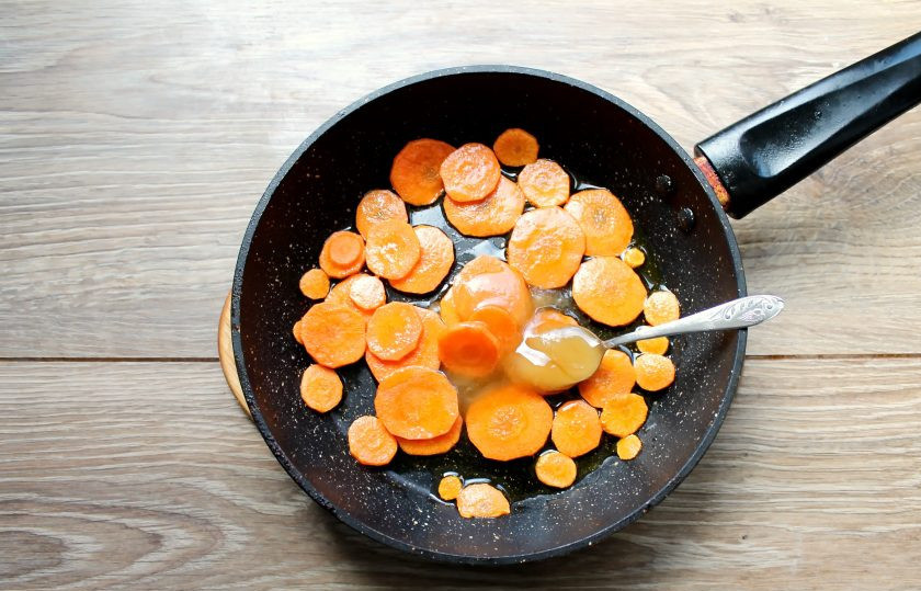 1. Этап. Еврейский цимес: Обжарьте морковь в течение 5 минут, перемешивая. Добавьте к моркови мед, перемешайте и готовьте еще 3 минуты. Мед должен стать тягучим.