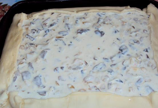 1. Этап. Пирог с грибами заливной: Готовое тесто размораживаем, затем раскатываем и выкладываем на смазанный растительным маслом противень, оставляем небольшие бортики. Выкладываем на тесто начинку, накрываем ее краями теста и заливаем яично-сметанной смесью.