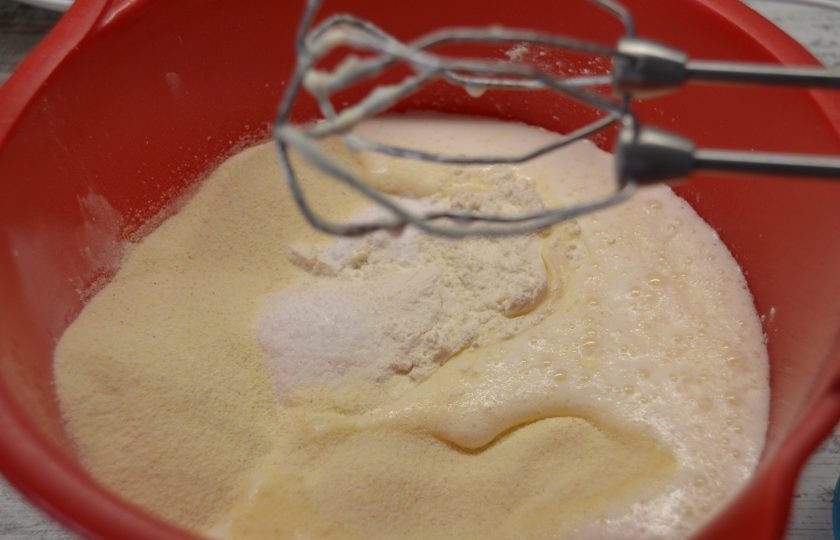 1. Этап. Манник с голубикой: Добавьте к взбитой яичной массе соль, ванильный сахар, манку, муку, соду, влейте кефир (или сметану), добавьте размягченное сливочное масло, еще раз взбейте до однородности.