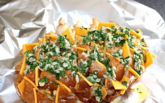 1. Этап. Сырный хлеб с зеленью: Посыпьте семенами горчицы или тмином. Заверните хлеб в фольгу и отправьте в разогретую до 200 градусов духовку на 15 минут.