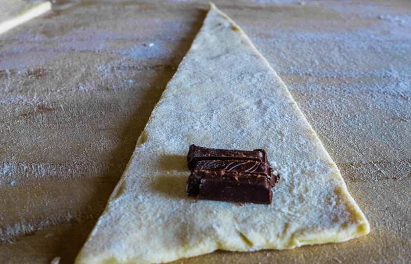 1. Этап. Круассаны с начинкой: Выложите кусочки шоколада с широкого края.
