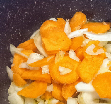 1. Этап. Гиганты с помидорами и харисой: В глубокой ёмкости разогреть масло. Добавить лук и морковь. Посолить Готовить на среднем огне, помешивая, 5 минут.