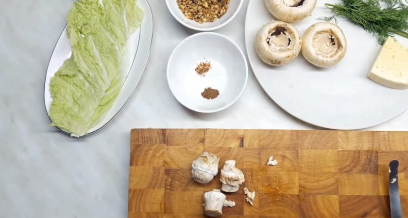 1. Этап. Грибы, фаршированные орехами и сыром: 1. Для начала аккуратно вырежьте ножки шампиньонов, оставив целыми шапочки. Нарежьте ножки грибов как можно мельче и отправьте к орехам, которые порубите острым ножом.