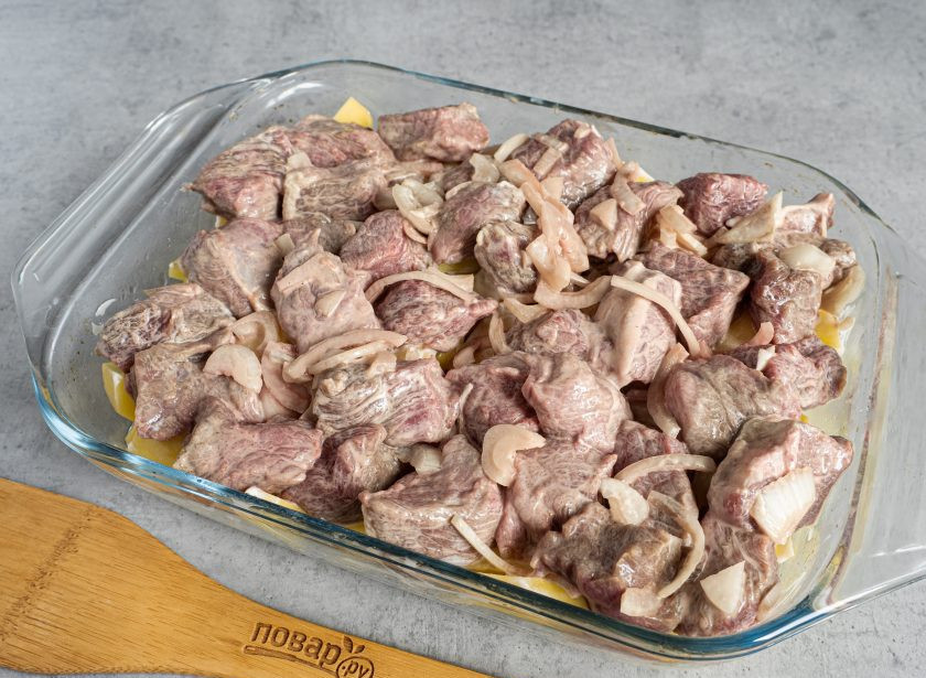 1. Этап. Лосятина с картошкой в духовке: Сверху выложите маринованное мясо. Накройте форму фольгой и запекайте при температуре 190 градусов 45-50 минут.