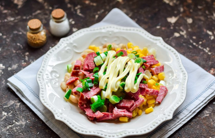 1. Этап. Салат с кукурузой, колбасой и фасолью: Заправьте салат майонезом, посолите и поперчите по вкусу. Перемешайте все и подавайте салат к столу.