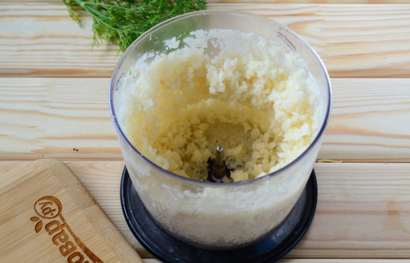 1. Этап. Нежнейшая пицца без муки: Начните с приготовления основы. Для этого измельчите в блендере или кухонном комбайне цветную капусту до состояния кашицы.