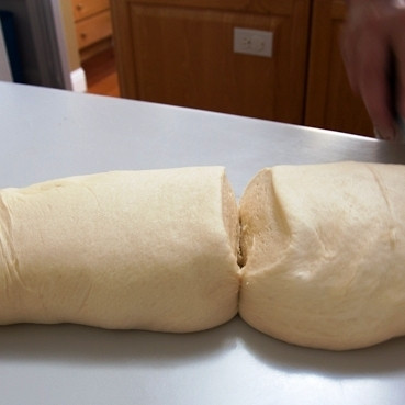 1. Этап. Вишневые бухты: Когда тесто подойдет, раскатываем из него бревно, которое делим на 6 равных частей.