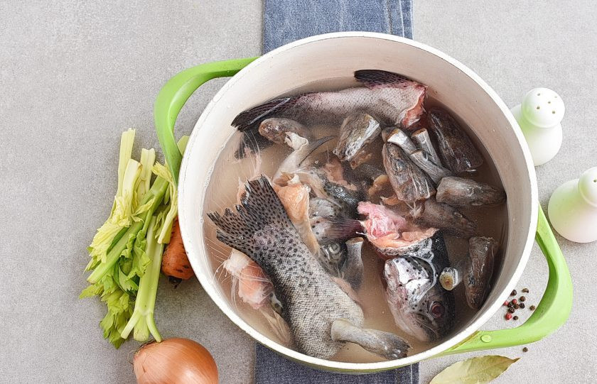 1. Этап. Бульон из рыбы: Тщательно промойте и вычистите рыбные головы и хвосты. Удалите жабры и сгустки крови, если они есть. Залейте рыбу холодной водой. Кастрюлю лучше брать широкую и низкую. На сильном огне доведите бульон до кипения и тщательно снимите пену.