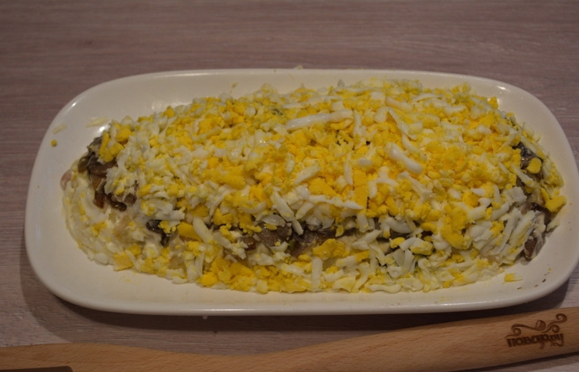 1. Этап. Салат Лисий хвост: Отварные яйца натрите на крупной терке. Распределите их по салату, придавая салату форму хвостика лисички. Смажьте майонезом.