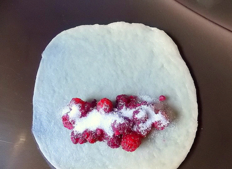 1. Этап. Хрустящие трубочки с малиной: Тонко раскатайте каждый шарик в форме прямоугольника. Положите часть малины и посыпьте сахаром.