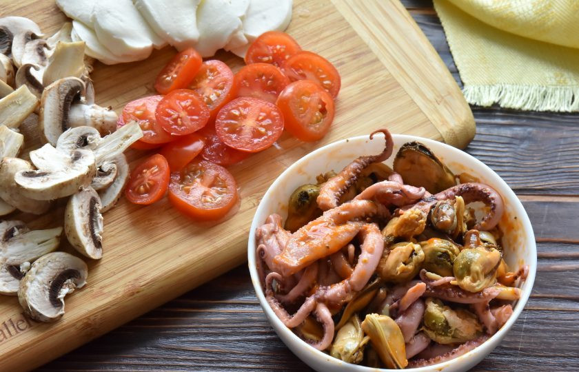 1. Этап. Пицца Том Ям: Подготовьте начинку для пиццы. С консервированных морепродуктов слейте маринад и добавьте в них 1 ст.л. пасты 