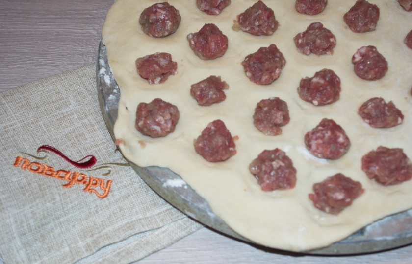 1. Этап. Пельмени из рисовой муки: Раскатайте небольшой кусочек теста на столе присыпанном мукой. Перенесите тесто на пельменницу. Открытой ладошкой похлопайте тесто по пельменнице, чтоб проявились дырочки, но тесто не должно прорваться. В каждую ячейку выложите по небольшой порции фарша.