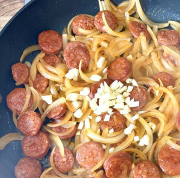 1. Этап. Быстрая сковорода Паста с чоризо: Обжарить чоризо и лук вместе около пяти минут, добавить чеснок, обжарить ещё минуты две.