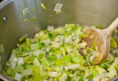 1. Этап. Суп с луком-порей: 2. Нарежьте мелко лук-порей, разогрейте кастрюлю со сливочным маслом и выложите лук.