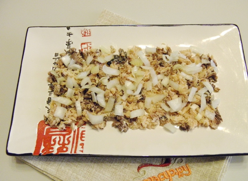 1. Этап. Салат Всем нравится: Разомните вилочкой сайру. Разложите её на тарелочке. Сверху распределите мелко порезанный репчатый лук. Если лук горький, ошпарьте его кипятком. Сделайте майонезную сеточку.