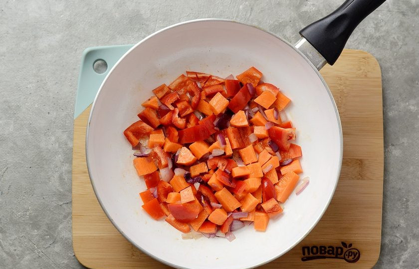 1. Этап. Австрийский тыквенный суп: Нарежьте кубиками лук, чеснок, морковь и перец. Обжарьте в сковороде в начале лук и чеснок, а потом добавьте морковь и красный перец.