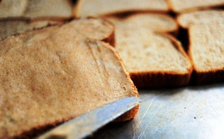 1. Этап. Вкусные гренки из белого хлеба: Намазываем каждый ломтик хлеба с одной стороны ароматным маслом, складываем ломтики на сухой противень.