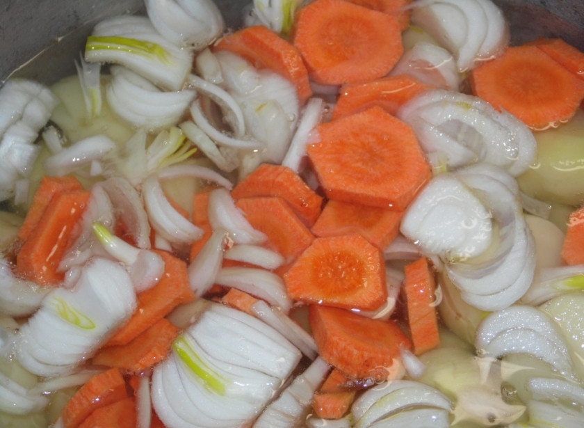 1. Этап. Овощное рагу с гусиным мясом: Ставим на огонь казан и наливаем в него воду. Ждем, пока закипит и вкидываем картофель. Вслед за ним лук и морковь.
